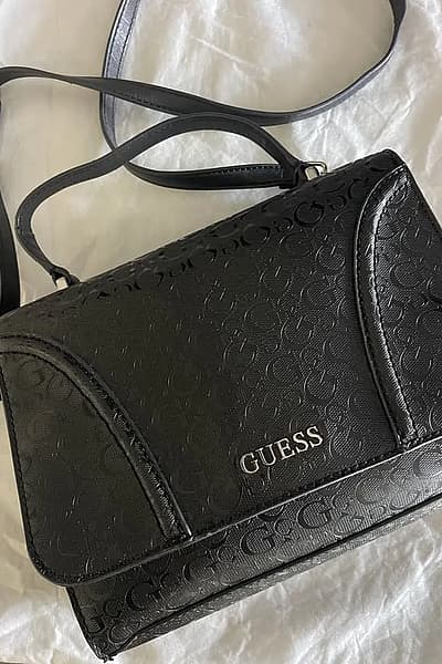 La borsa nera Guess viene fornita con una custodia by GUESS — pre-loved on Thrifted.mt