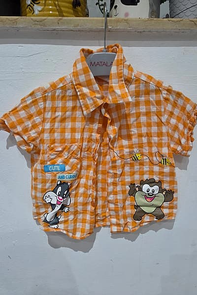 Maglietta a quadretti arancioni con personaggio — pre-loved on Thrifted.mt